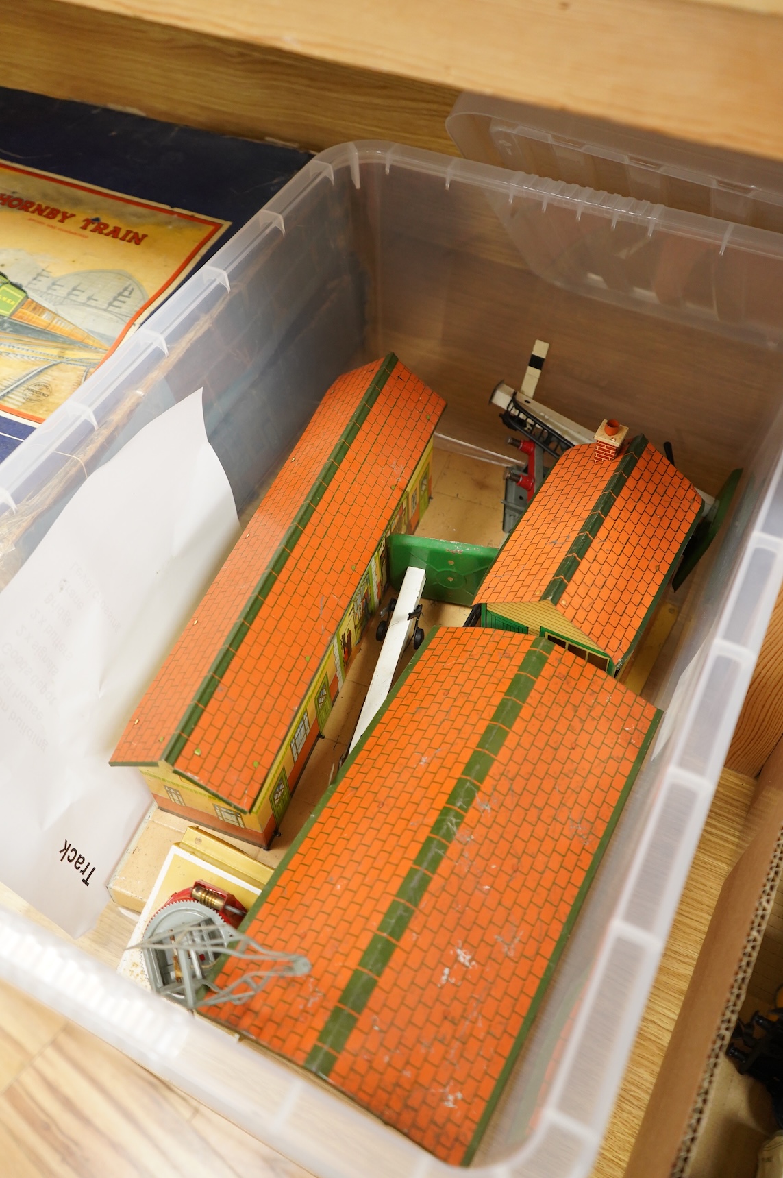 A collection of 0 gauge Hornby tinplate clockwork railway, including four BR locomotives, 17 freight wagons and four wheel coaches, together with a station building, signal cabin, and Goods depot (missing base), plus a f